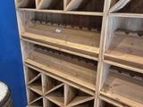 Les étagères sont en bois et contiennent de nombreuses bouteilles de vin.
