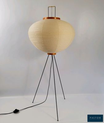 une lampe blanche avec un socle en bois montée sur un trépied