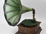 un gramophone vert et noir posé sur un socle en bois