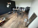 une pièce équipée d'un bureau, de chaises et d'une télévision