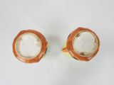 pair of orange and white vases on a white surface
