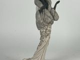 figurine représentant une femme en robe blanche tenant un téléphone portable