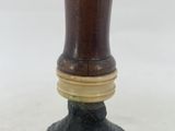 a wooden vase with a black base on a white background