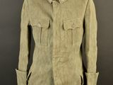an old military coat on a mannequin stand against a black background