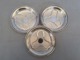 three silver plated dishes on a table with a white table cloth