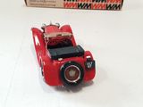 a red toy car sitting on a table next to a box