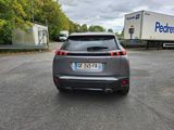 a car that is parked in a parking lot with a trailer in the background