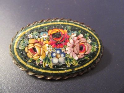 une photo d'une broche ornée de fleurs