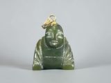 a green jade buddha figurine sitting on a white surface