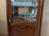 une armoire en bois avec une porte vitrée, sur laquelle est posé un vase