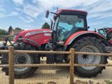 un tracteur rouge garé derrière une clôture