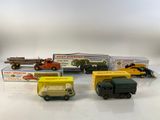 several toy trucks are lined up in a row on a white surface
