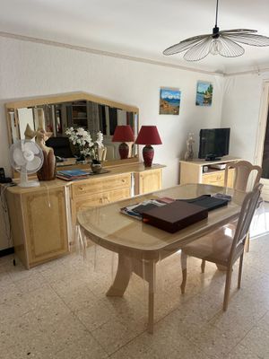 une salle à manger avec une table, des chaises et une télévision