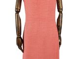 Le mannequin est en bois et porte une robe rose.
