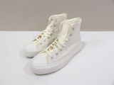 white high top converse sneakers with lace trims on a white surface