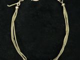 a silver bracelet with two silver beads on a black background