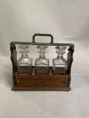 trois carafes dans un coffret en bois sur fond blanc