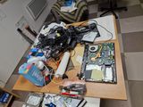 a table with a laptop and a lot of electronics on it