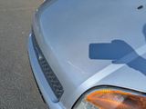 a shadow of a person holding a cell phone on the hood of a car