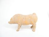 a small figurine of a pig on a white surface