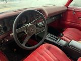 a red interior of a car with a steering wheel and dashboard