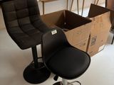 une chaise noire placée devant une table sur laquelle se trouve une boîte
