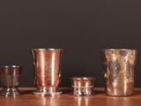 quatre types différents de vases en argent posés sur une table en bois