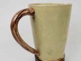 a coffee cup with a wooden handle on a white table