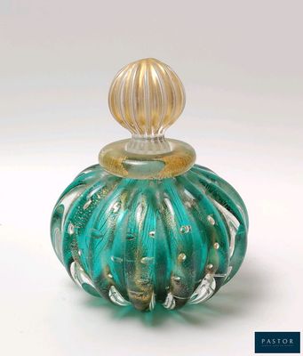 un flacon de parfum en verre vert avec un bouchon doré