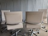 three office chairs sitting in front of a metal wall in a warehouse