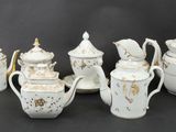 six pieces of white and gold tea and coffee set on a black background
