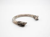 un gros plan sur un bracelet en argent orné de deux têtes de mort