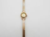l'image d'une montre en or sur une surface blanche