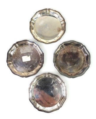 trois plats plaqués argent sur un fond blanc, avec un miroir au centre