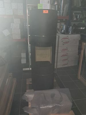 un réfrigérateur noir posé au milieu d'une pièce où se trouvent de nombreux cartons par terre