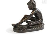 an image of a bronze statue of a woman sitting on a rock