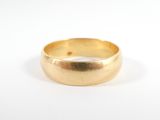 gros plan d'une bague en or sur une surface blanche