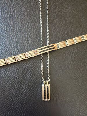a close up of a necklace on a black leather surface