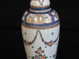 a white vase with blue and pink flowers on it