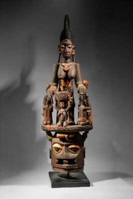 une grande statue en bois représentant une femme avec un oiseau sur la tête