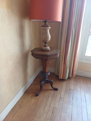 a small table with a lamp on it in the corner of a room