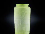 un vase vert posé sur une surface noire