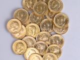 a pile of gold coins sitting on a white surface