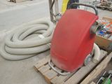 a red vacuum sitting on a pallet next to a box of tools