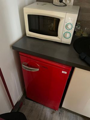 un micro-ondes et un petit réfrigérateur rouge dans une petite cuisine