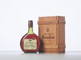 a bottle of brandy sitting next to a wooden box
