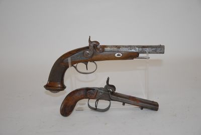 two old guns are on display on a white surface