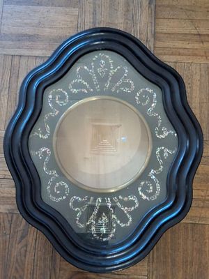 a picture of a black and gold plate on a wooden floor