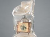 a bag with a clock inside of it sitting on a pedestal