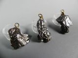 three pieces of silver metal are sitting on a white surface